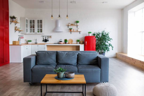 Modern open plan kitchen with living area and big window.